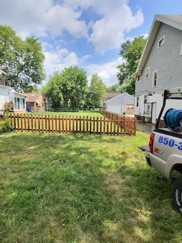 Wood picket fence after professional cleaning — warm natural wood tone restored and ready to seal