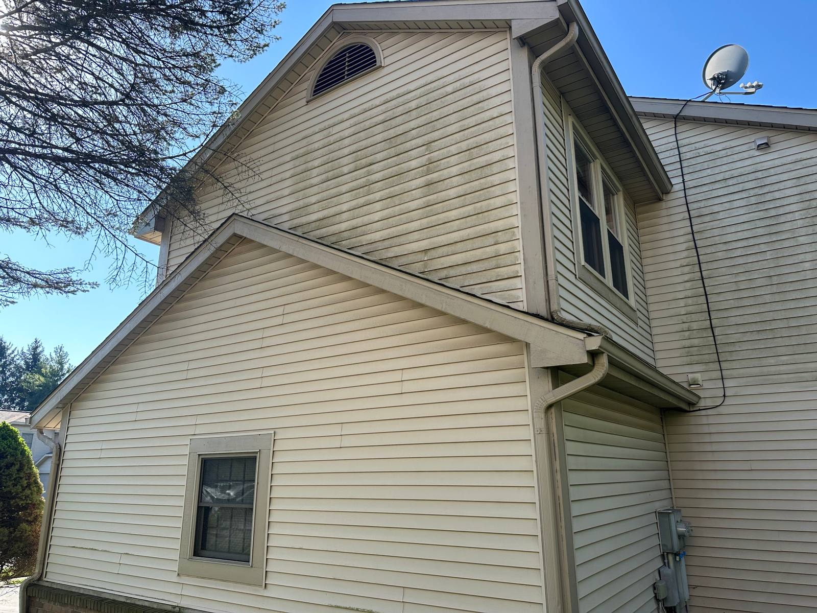 Two-story Sylvania home gable before soft washing with algae streaks