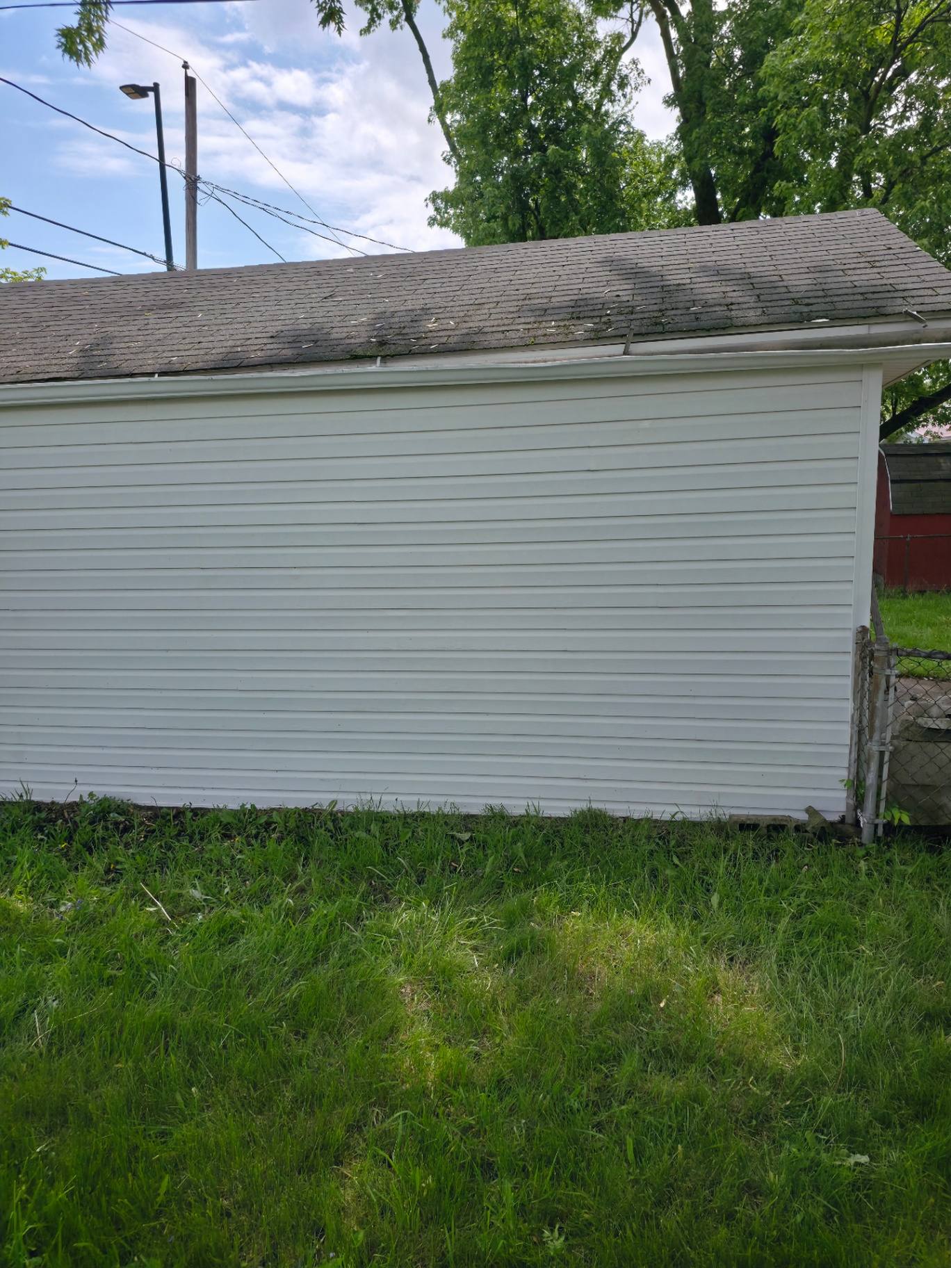 Garage siding after soft washing — clean white panels with algae fully removed