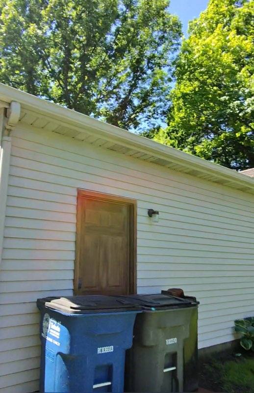 Side of garage after soft washing — bright clean white siding restored