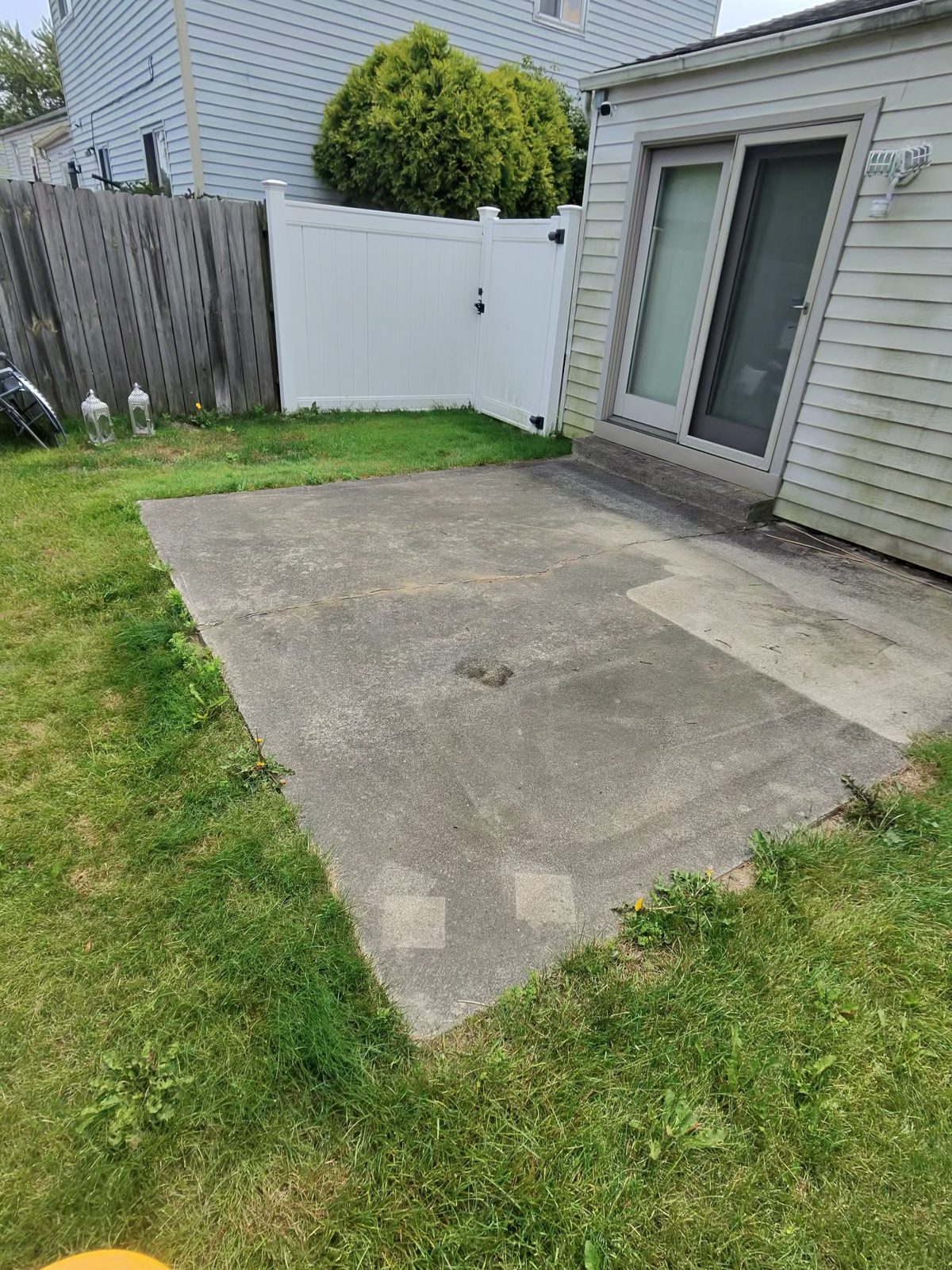 Backyard concrete patio before pressure washing — dirty stained concrete