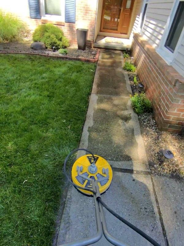Front walkway before pressure washing with stained concrete and embedded dirt and grime